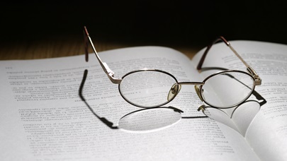 AI Otevřená kniha s brýlemi na stránkách, vrhající stín ve tvaru srdce.