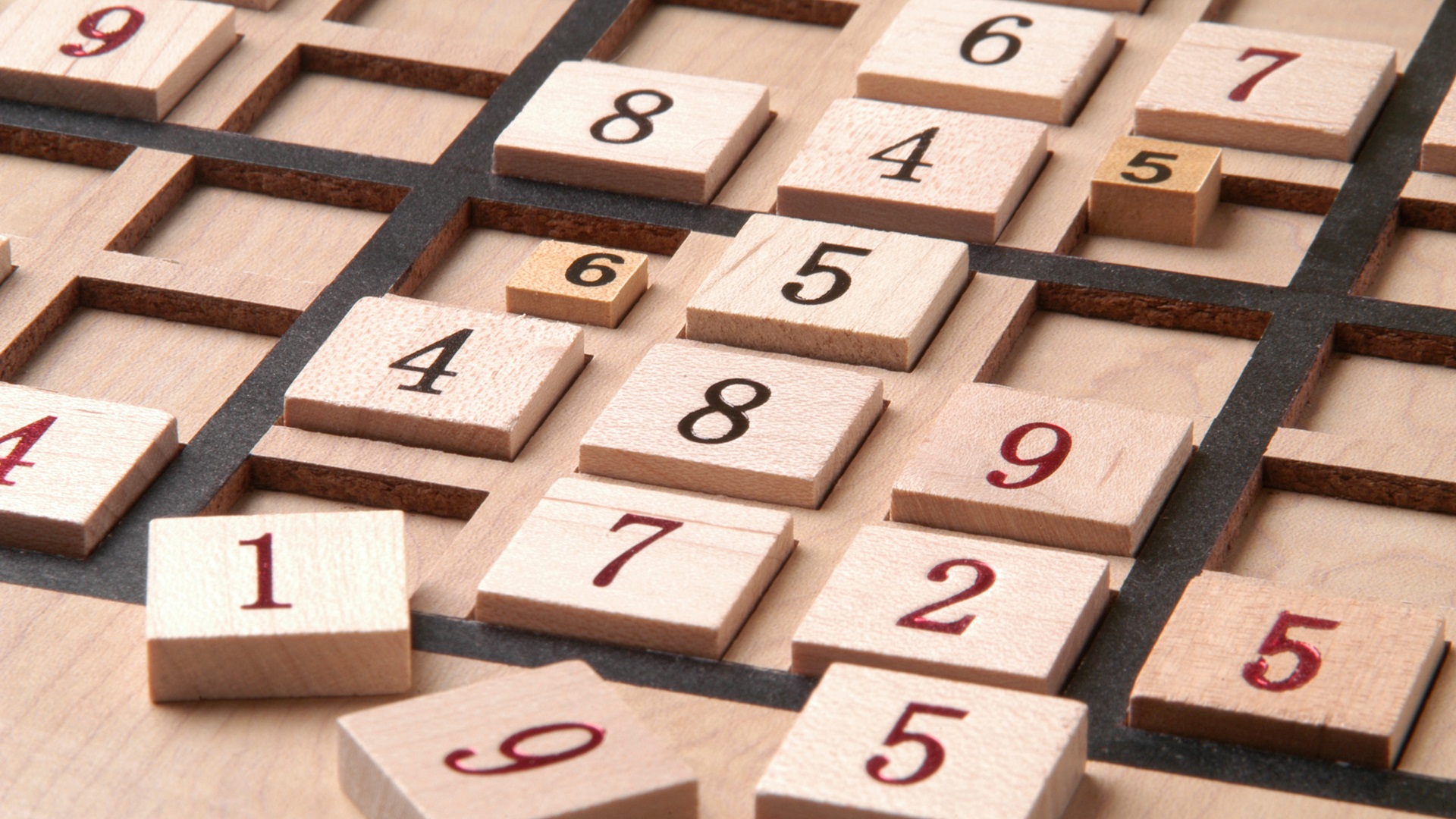 Dřevěná deska s čísly a volnými políčky, připomínající sudoku. Symbolizuje trénink paměti a kognitivních funkcí.